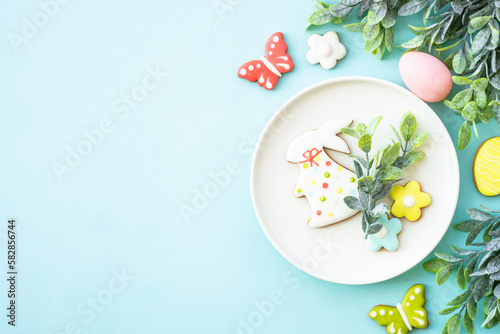 Easter food background. White plate with eggs, spring flowers and easter cookies. Flat lay.