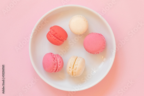 Macaroon selection in feminine colors like pink, red and egg white. Premium dessert selection in a top view image.