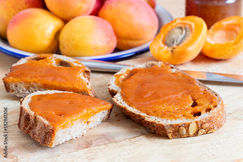 Home made apricot jam on sourdough bread with ripe apricots in the background