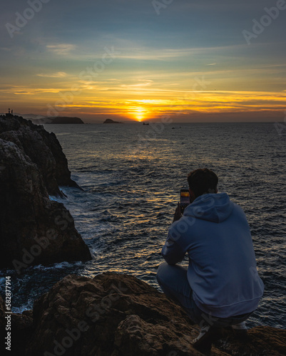 boy taking a picture of a beautiful sunset © Alvaro