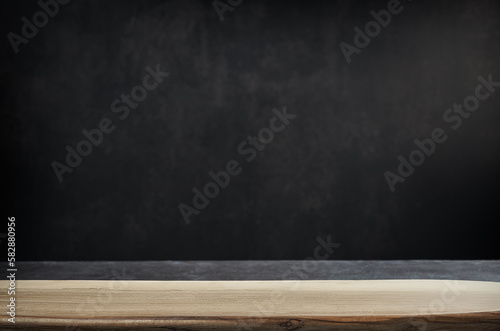 Empty table with wooden board and dark background