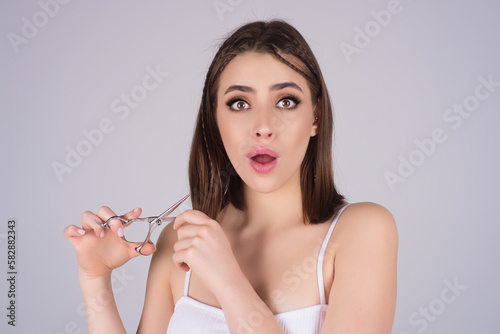 Woman with scissors in studio. Elegant woman from hairdressers salon. Girl with straight hair with professional scissor. Haircare concept. Hairdresser scissors, haircut accessories. photo