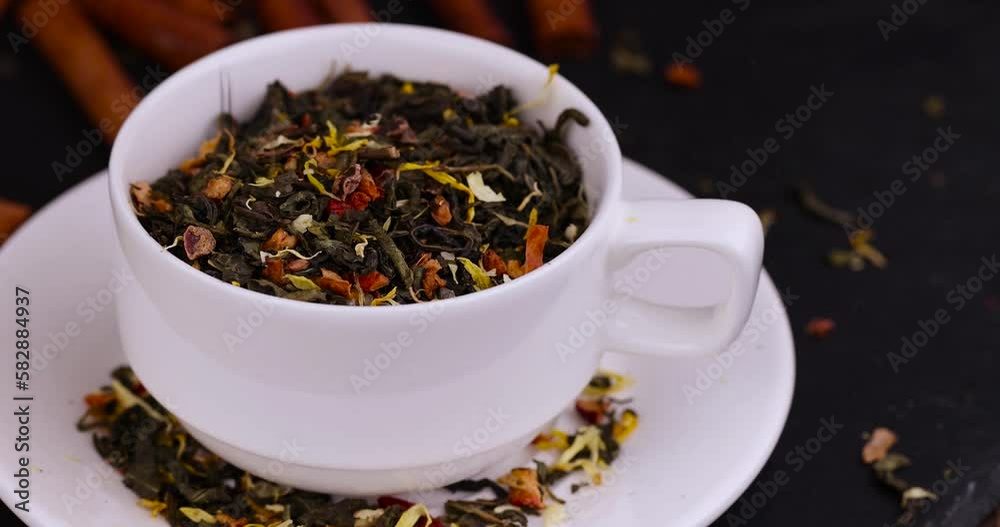 A large amount of dry green tea with pieces of fruit A large amount of dry green tea with pieces of fruit