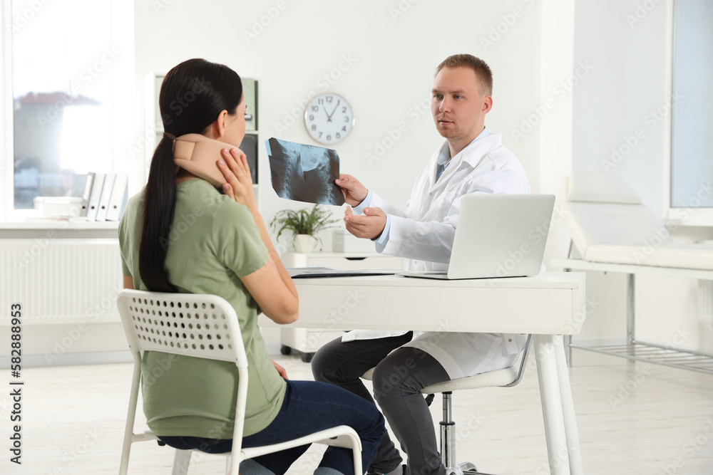 Obraz premium Doctor with neck MRI image consulting patient in clinic