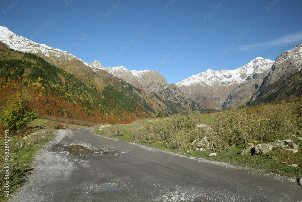 Picturesque view of empty gravel road in mountains on sunny day Picturesque view of empty gravel road in mountains on sunny day