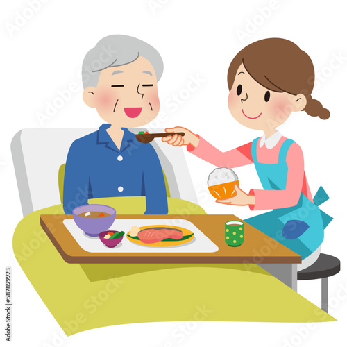 おじいさんの食事のお世話をする介護士