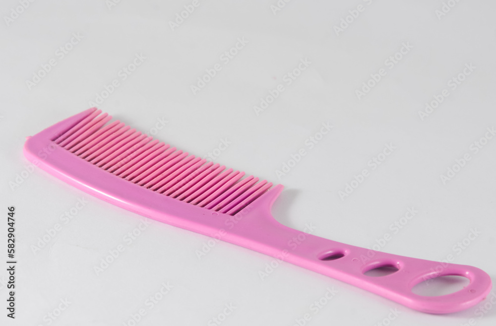 pink plastic hair comb isolated on a white background pink plastic hair comb isolated on a white background