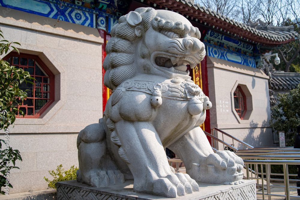 A stone lion in china ,with old building,