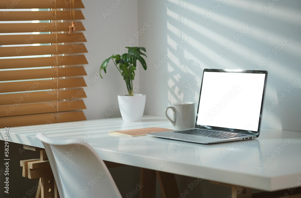 Modern home office interior with laptop, cup of coffee and houseplant on white working desk. Modern home office interior with laptop, cup of coffee and houseplant on white working desk.