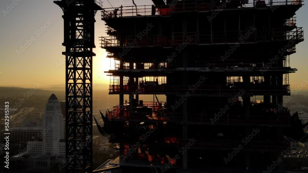Aerial shot of a new high-rise building under construction at sunrise Aerial shot of a new high-rise building under construction at sunrise