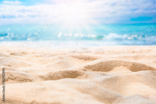 Beach sand background for summer vacation concept. Beach nature and summer seawater with sunlight light sandy beach Sparkling sea water contrast with the blue sky.