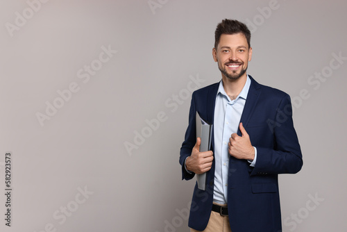 Happy teacher with stationery against beige background. Space for text