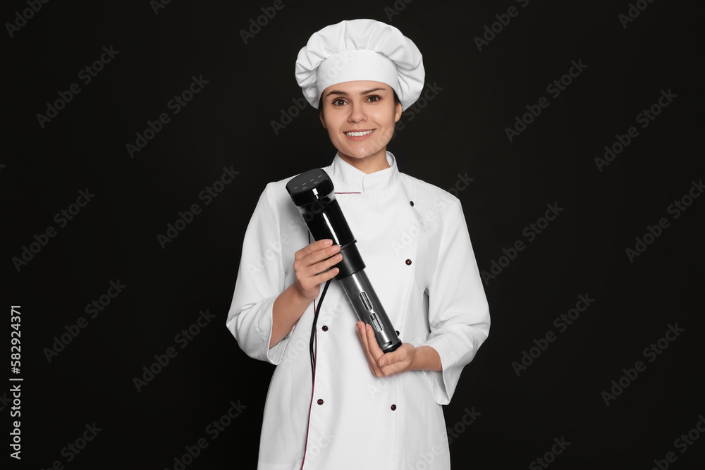 Chef holding sous vide cooker on black background Chef holding sous vide cooker on black background