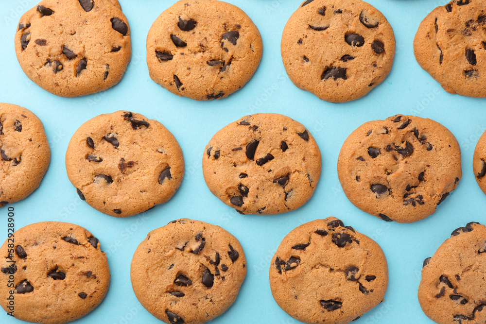 Many delicious chocolate chip cookies on light blue background, flat lay Many delicious chocolate chip cookies on light blue background, flat lay