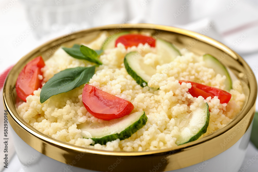 Tasty couscous with tomatoes, cucumber and basil on table, closeup Tasty couscous with tomatoes, cucumber and basil on table, closeup