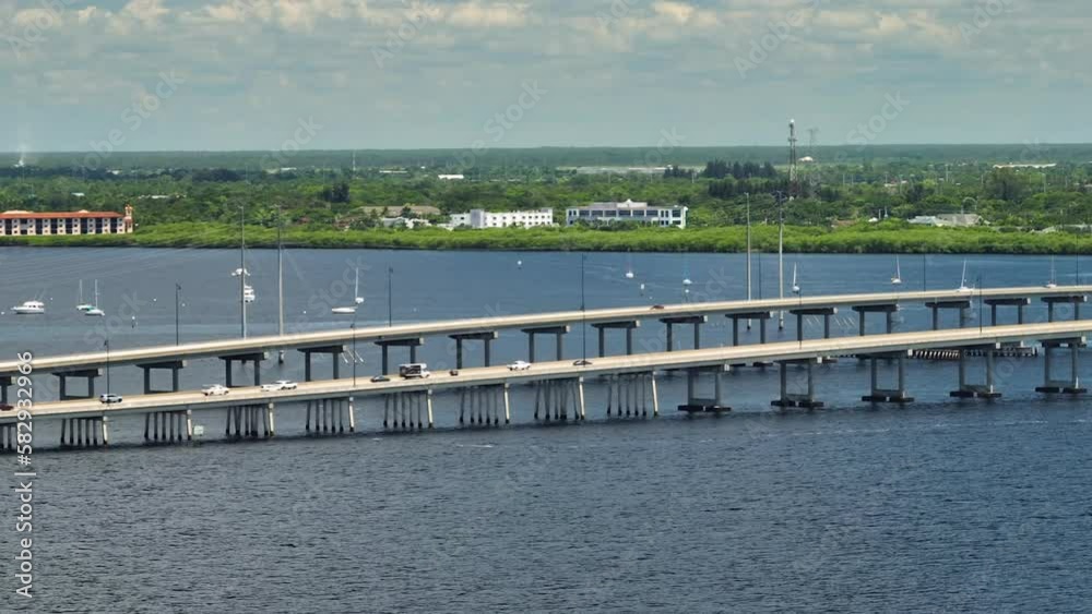 Aerial view of Barron Collier Bridge and Gilchrist Bridge in Florida with moving traffic. Transportation infrastructure in Charlotte County connecting Punta Gorda and Port Charlotte over Peace River Aerial view of Barron Collier Bridge and Gilchrist Bridge in Florida with moving traffic. Transportation infrastructure in Charlotte County connecting Punta Gorda and Port Charlotte over Peace River
