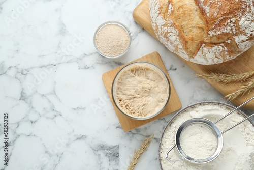 Flat lay composition with sourdough on white marble table. Space for text