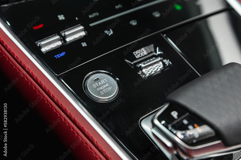 Car engine push start stop button ignition remote starter. Car dashboard:  black engine start stop button, car interior details.