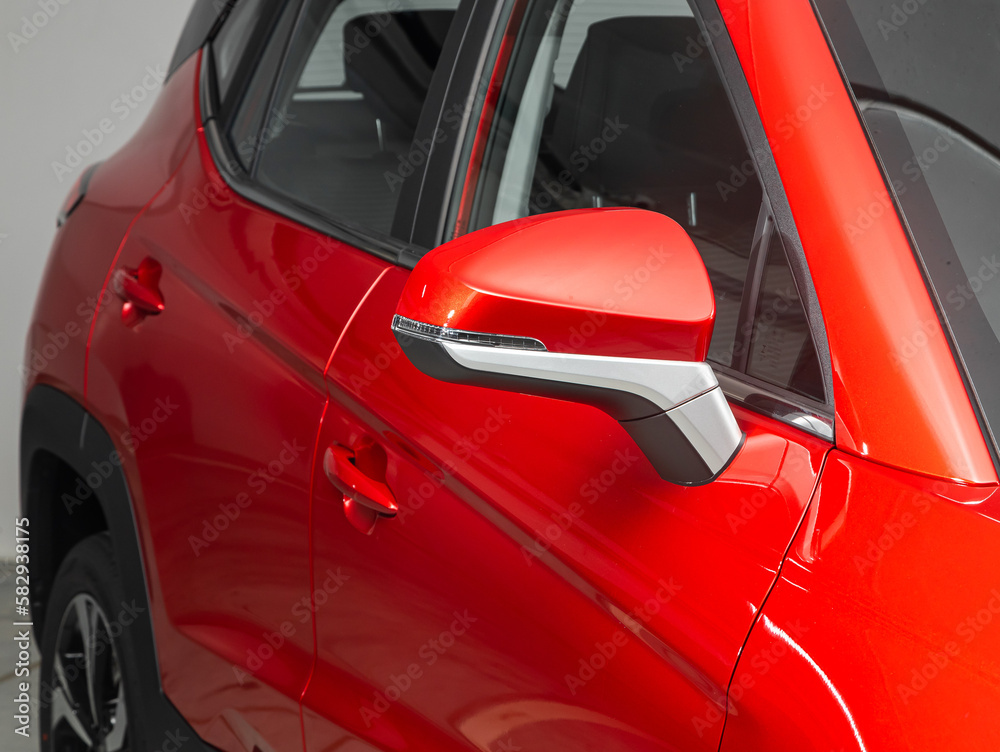  Side mirror of a  red car close-up. Exterior detail