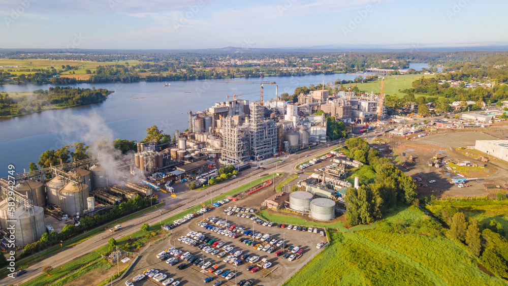 Aerial drone view of a large industrial grain mill at Bomaderry in the City of Shoalhaven, NSW, Australia with Shoalhaven River in the background 