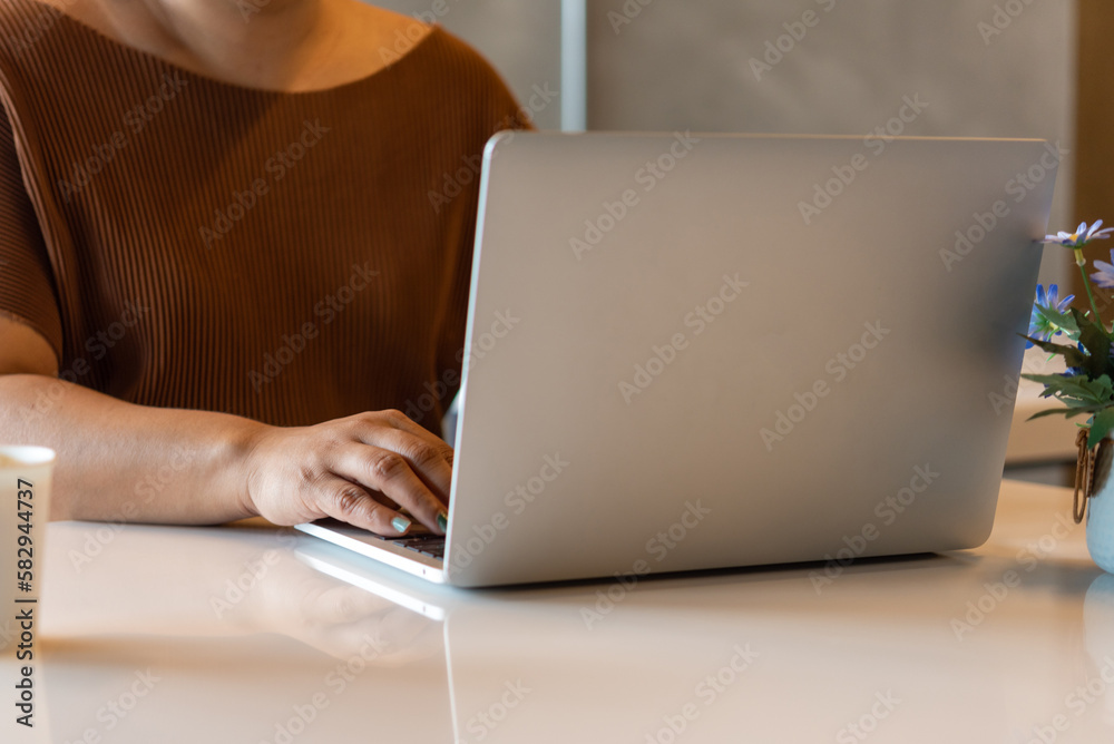 Fototapeta premium Woman working typing on keyboard laptop computer searching information on keyboard close up. technology digital, online communication, working from home, freelancing, e-commerce,