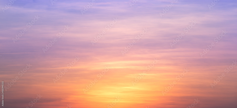Real amazing panoramic sunrise or sunset sky with gentle colorful clouds. Long panorama, crop it. Evening sky scene with golden light from the setting sun
