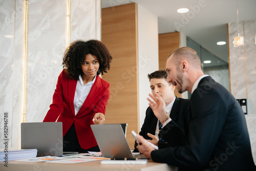 Group of young business people discussing business plan at modern startup in creative business discussing work modern office building.