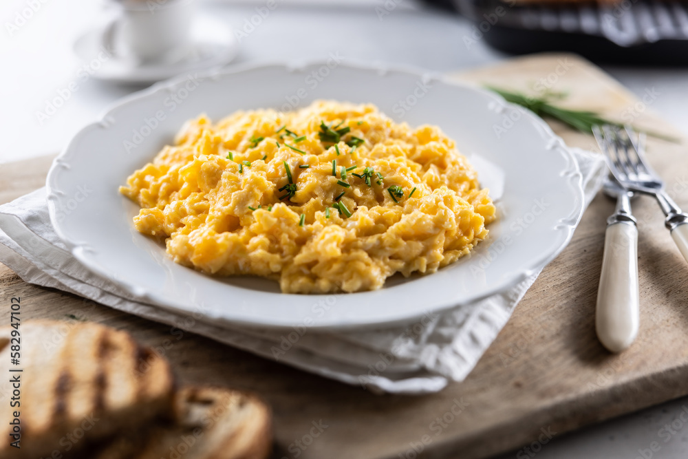 Appetizing breakfast full of proteins in a form of scrambled eggs in a plate