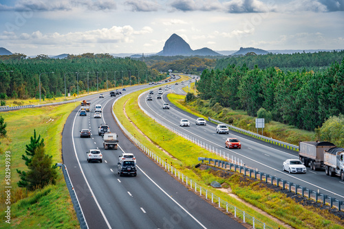 Queensland, Australia - Cars moving along Bruce Hwy with Glass House mountains in the background photo