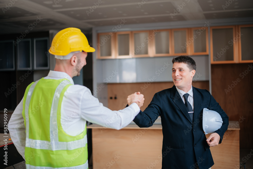 Engineers or architecture shaking hands at construction site for architectural project, holding safety helmet on their hands. successful cooperation concept. Engineers or architecture shaking hands at construction site for architectural project, holding safety helmet on their hands. successful cooperation concept.