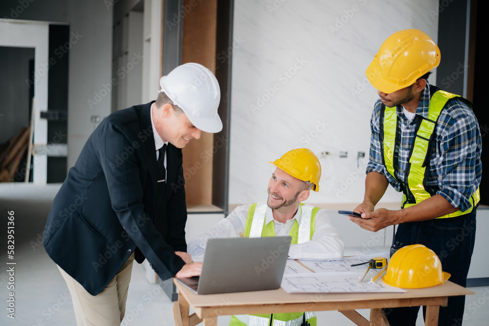 Architect caucasian man working with colleagues mixed race in the construction site. Architecture engineering on big project. Building in construction interior.. Architect caucasian man working with colleagues mixed race in the construction site. Architecture engineering on big project. Building in construction interior..