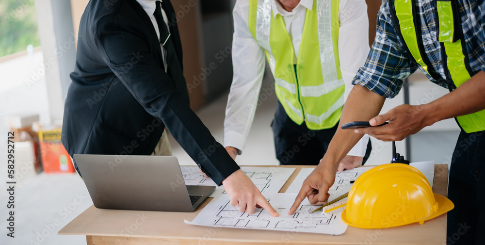 Creative architect projecting on the big drawings in the dark loft office. industry professional team