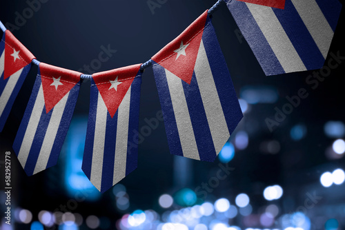 Fototapeta Naklejka Na Ścianę i Meble -  A garland of Cuba national flags on an abstract blurred background