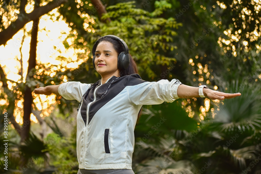 happy person with headphones in park doing exercise happy person with headphones in park doing exercise