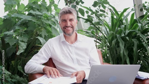 business man with a laptop looking at the camera .