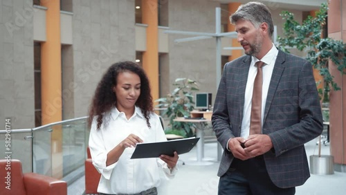 business woman and a businessman discussing business documents .