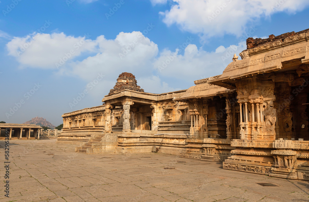 Medieval stone architecture with intricate carvings inside Vijaya Vittala temple at Hampi, Karnataka, India