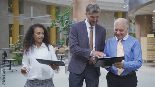 multinational business team with business documents walking through the office lobby.