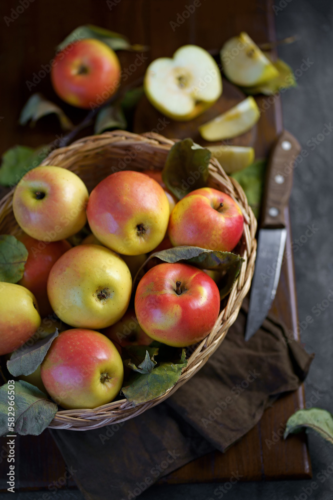 Ripe apples in a basket, with leaves around it Ripe apples in a basket, with leaves around it
