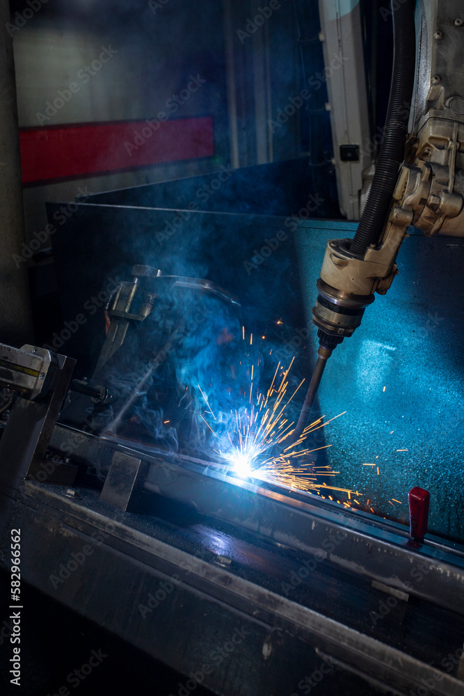 Fototapeta premium Industrial welding robot. Robot coded to weld is working. Digital production operation. Industry 4.0