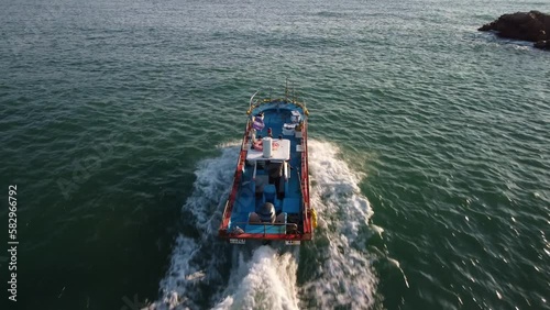 Rear aerial view of a small fishing boat in the morning in Ilsan harbor, Ulsan district, South Korea. photo