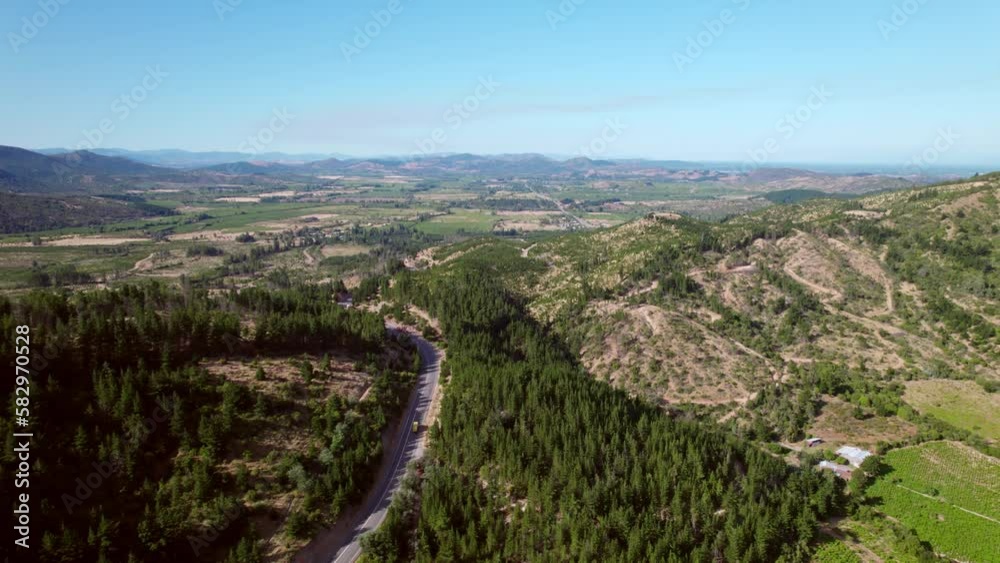 Establishing shot of a road running through the Maule Valley vineyards and mountains Establishing shot of a road running through the Maule Valley vineyards and mountains