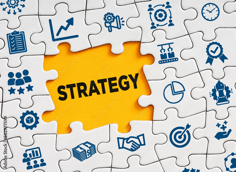 Business strategy concept. The word business strategy I in a missing puzzle piece with business symbols. Business strategy concept. The word business strategy I in a missing puzzle piece with business symbols.