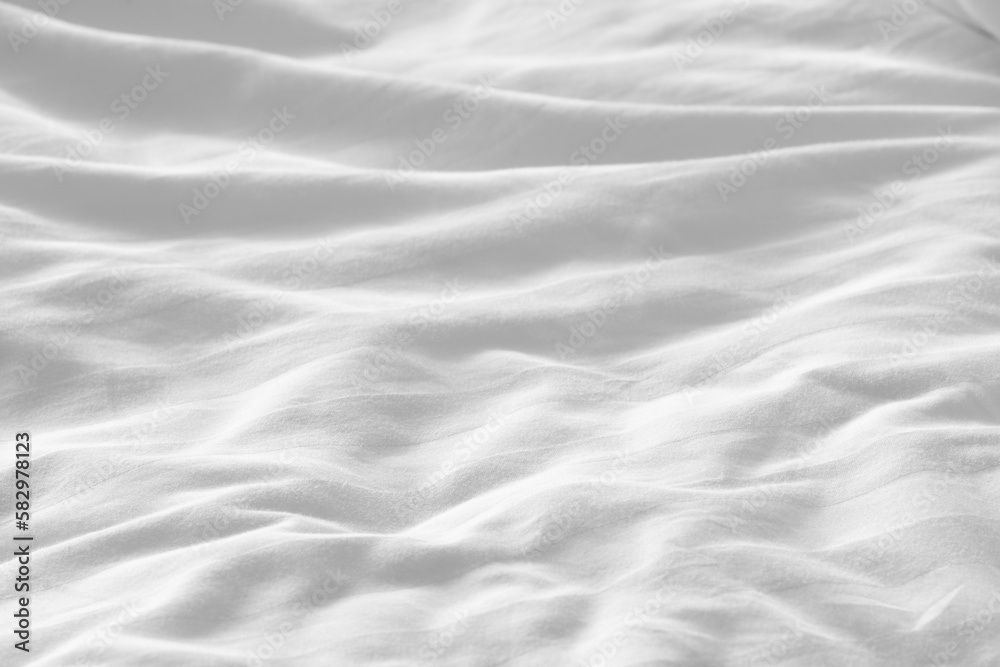 Wrinkled white bedsheet background. Cozy fabric texture surface. Untidy duvet backdrop. Relaxation and comfortable accommodation. Wrinkled white bedsheet background. Cozy fabric texture surface. Untidy duvet backdrop. Relaxation and comfortable accommodation.