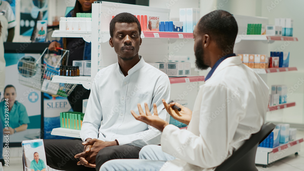 Obraz premium Health specialist using otoscope to do ear examination with male customer, checking infection for otolaryngology consult. Young specialist helping man with disease, giving pills. Handheld shot.