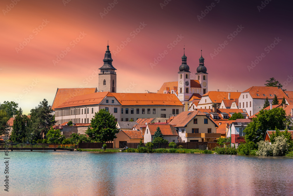 Fototapeta premium View of Telc across pond with reflections, South Moravia, Czech Republic.