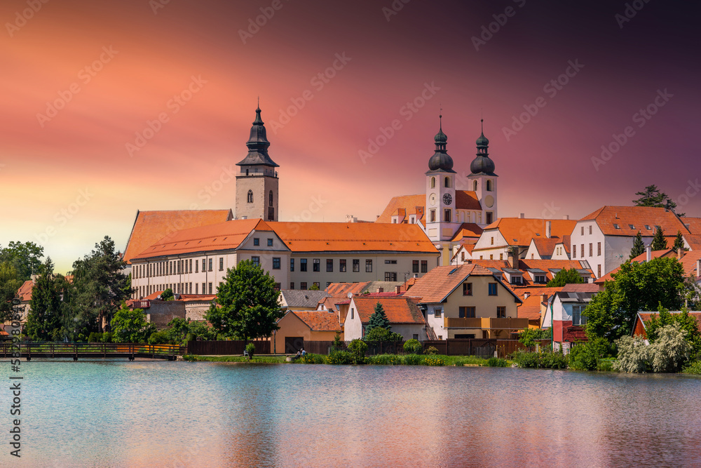 View of Telc across pond with reflections, South Moravia, Czech Republic.