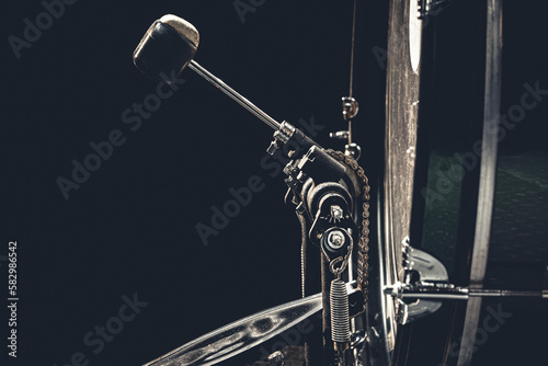 Bass drum with pedal, musical instrument on black background. photo