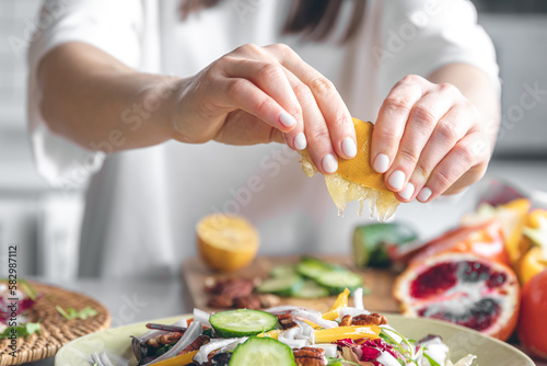 A woman makes a fresh vegetable salad, close-up.