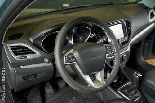 dark gray car interior with light inserts. dashboard, controls, deflectors, music system